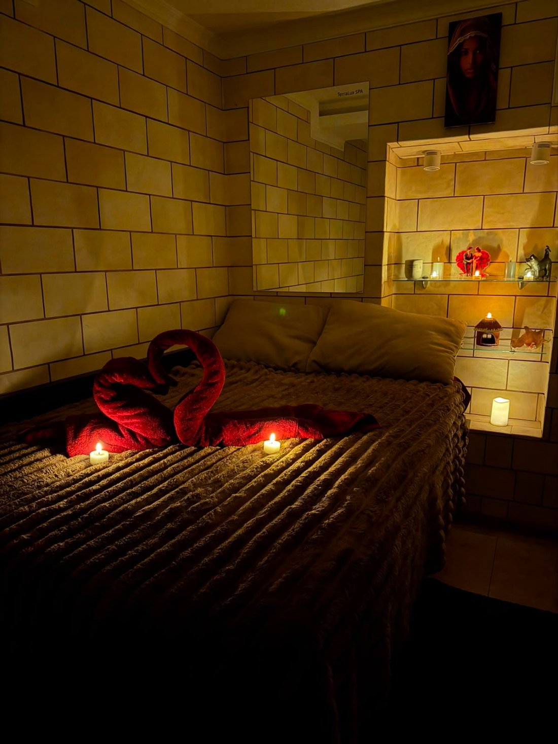 Cameră de masaj pentru doi la TerraLux SPA — lumânări aprinse și prosoape aranjate în formă de inimă